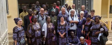 Plan serré sur les participants au programme de coopération kindia en Guinée, dans leur costumes traditionnels marron et bleu clair