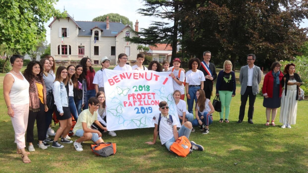 Elus, services municipaux et membres associatifs avec des représentants adlutes et enfants de Lésina en Italie, posant devant l'Hôtel de Ville de Bouaye